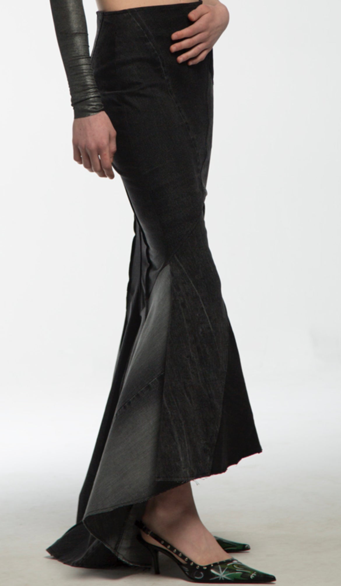 A woman wearing sandasimona black denim skirt on the white background.