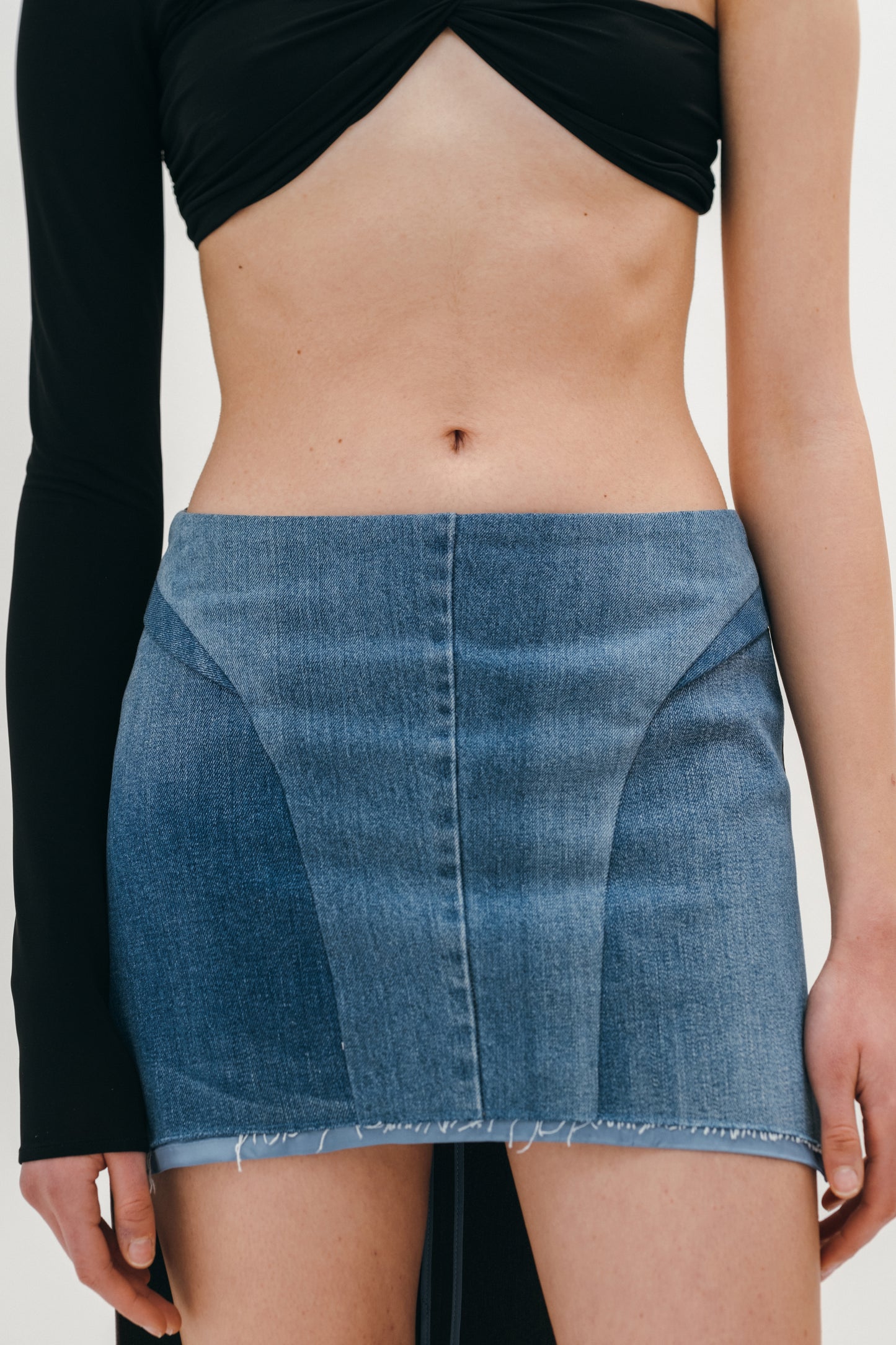 A model showing the skirt made of wool and denim from the front side on the white background