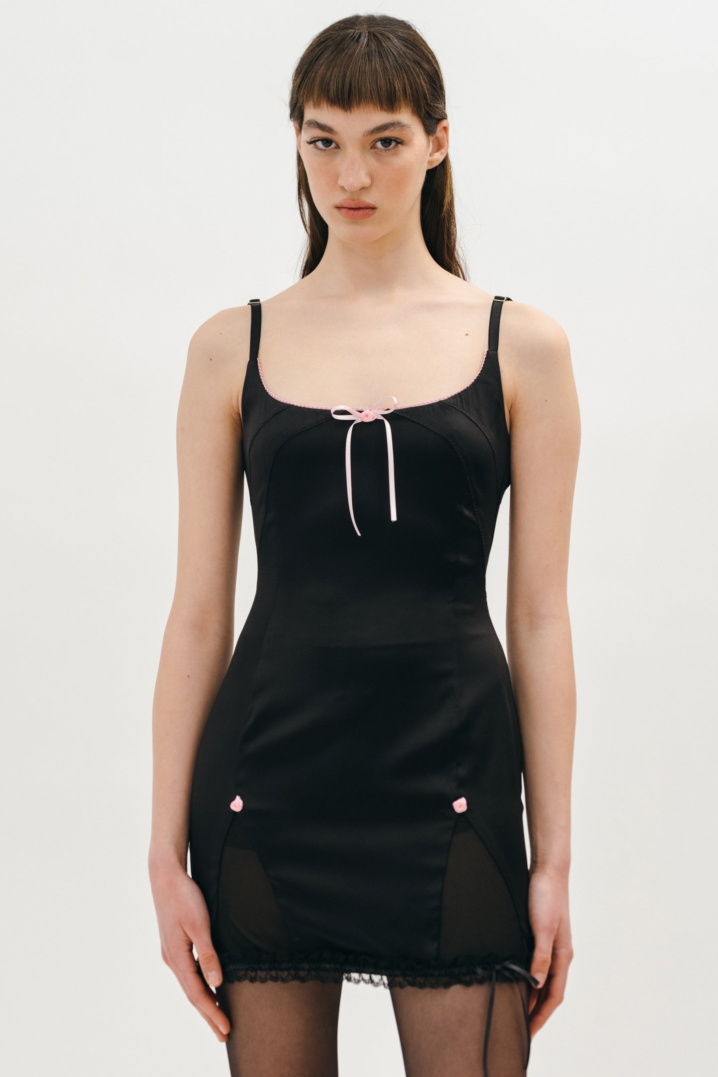 A woman wearing sating black dress with bows