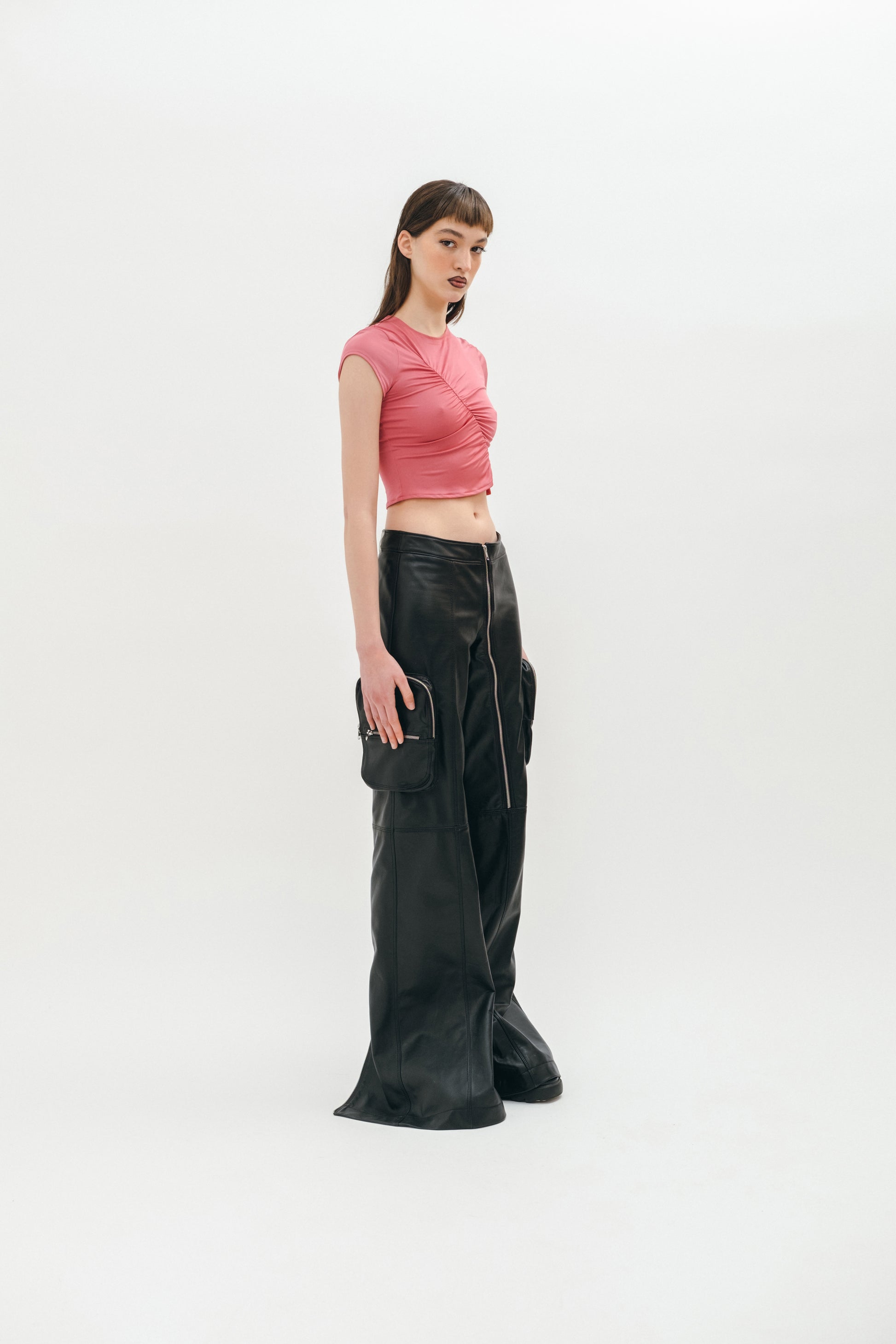 A woman standing wearing sandasimona leather pants on the white background